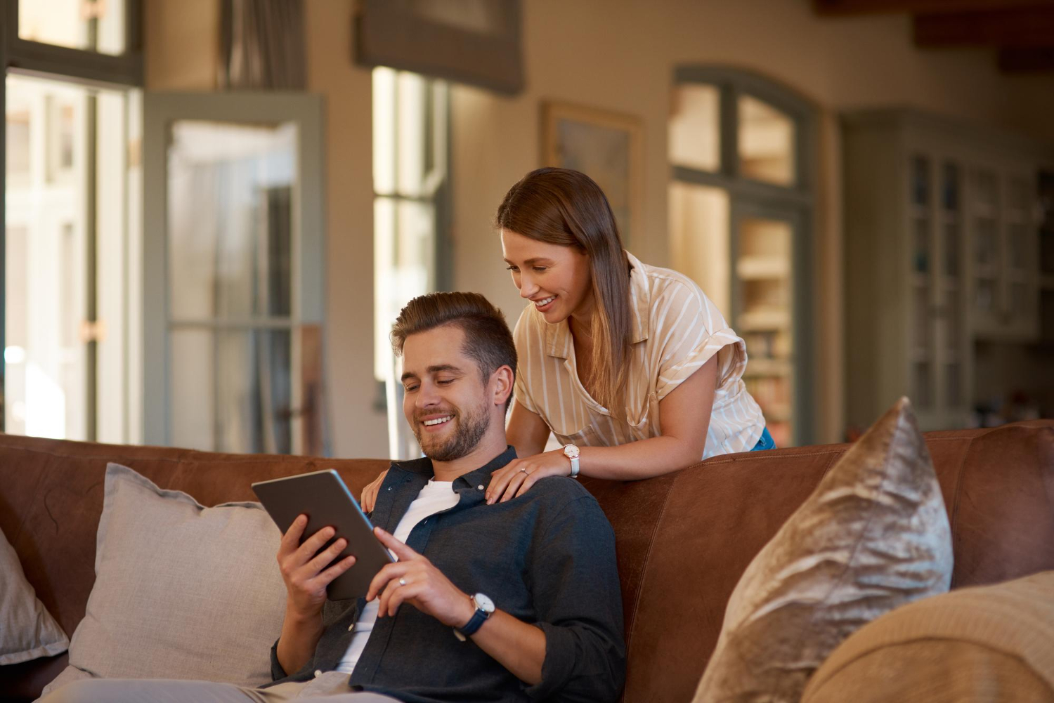 A couple relaxing at home with a tablet